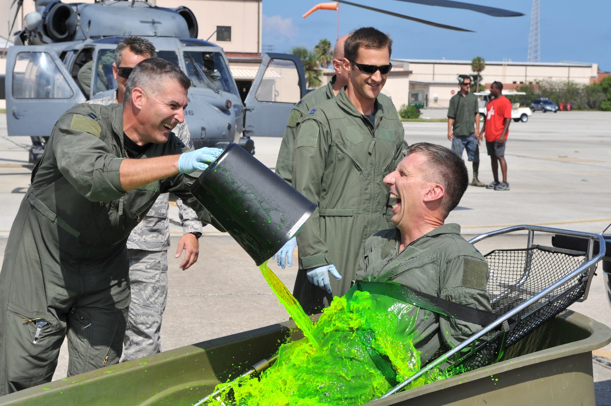 PATRICK AIR FORCE BASE, Fla. - Neon green water is poured on Col. Macrander as he sits strapped in to a stokes litter and partially submerged in the ice-cold water. (U.S. Air Force photo/John Connell)