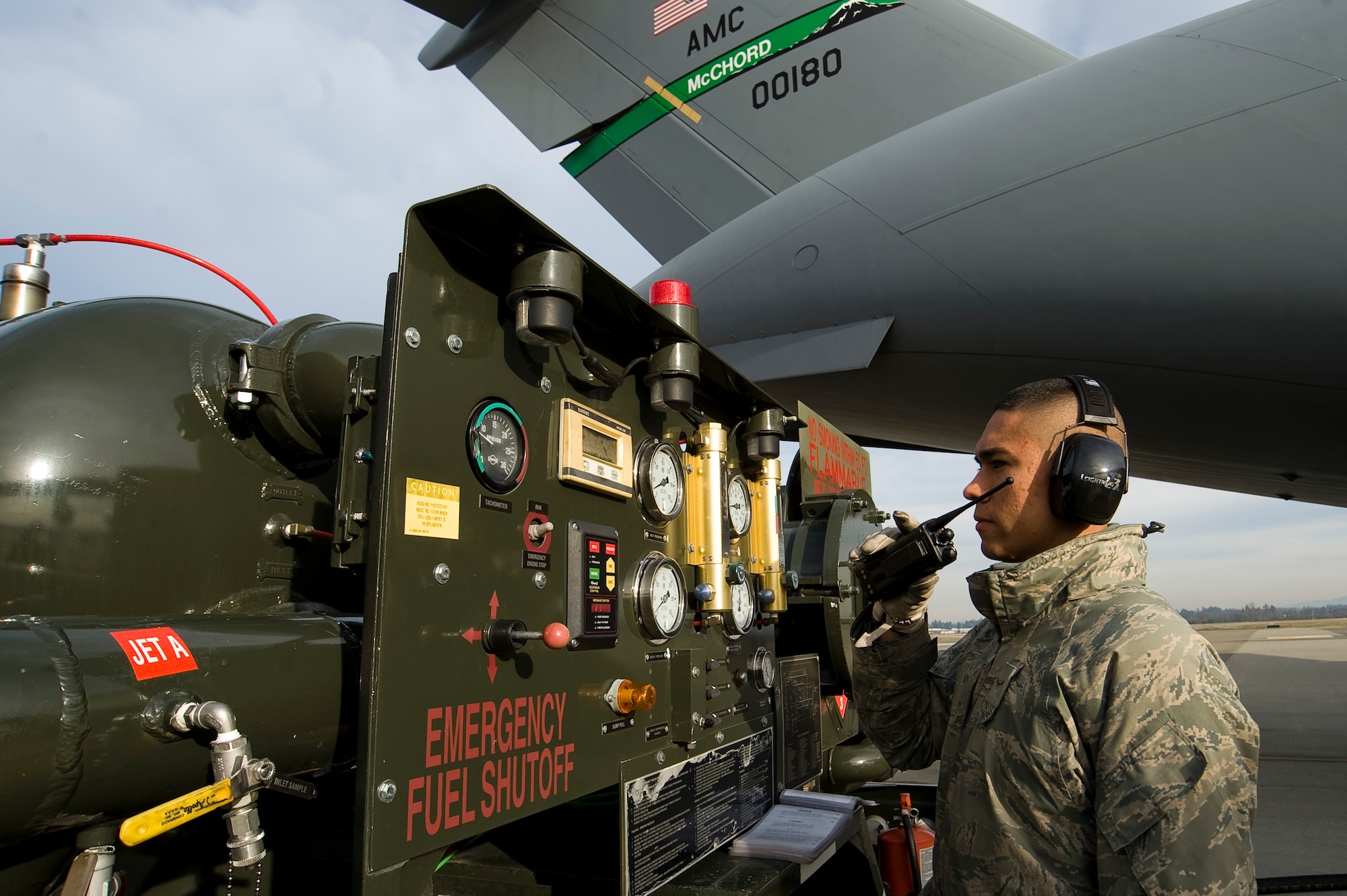 Airman Julio Chavez, a fuels distribution operator assigned to the 62nd Logistics Readiness Squadron here, radios information following a successful issue of the new Jet A commercial fuel in a C-17 Globemaster III on the McChord flightline Thursday. (U.S. Air Force photo/Abner Guzman)