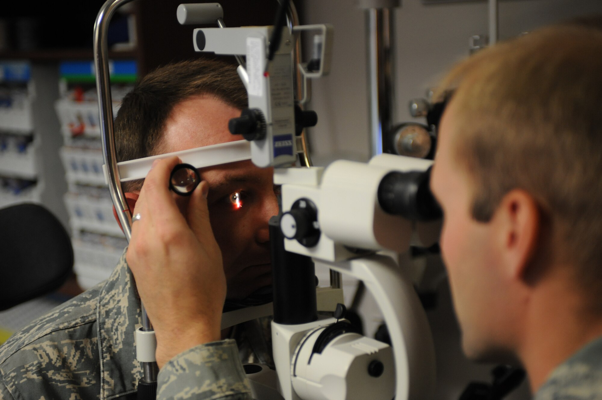 (Right) Major Michael Bogaard, 28th Medical Group chief of optometry, uses a bio-microscope during Tech Sgt. Heath Sowers, 28th Logistics Readiness Squadron non-commissioned officer in charge of receiving yearly evaluation, Dec 1. The microscope is used to examine the front and back surface of the eye. (U.S. Air Force photo/Airman 1st Class Adam Grant)
