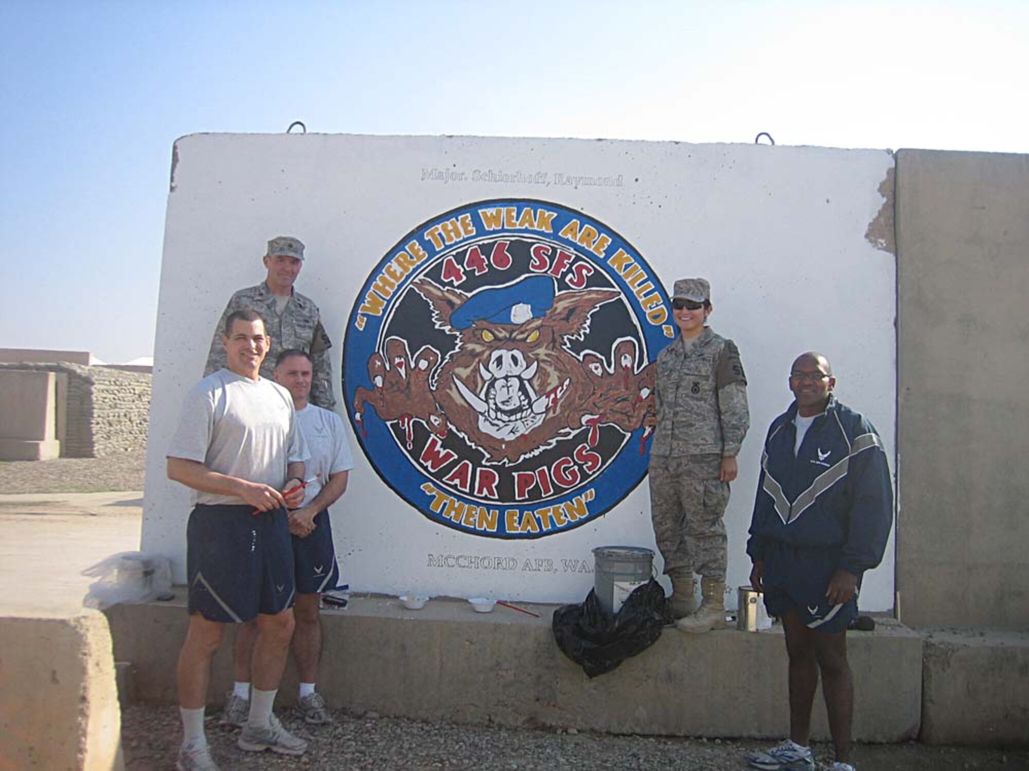 KIRKUK REGIONAL AIR BASE, Iraq - Leaving their mark with a painting of the 446th Security Forces Squadron's Warpig coin at Kirkuk RAB are Tech. Sgt. John Wulff, Tech. Sgt. Mike Lefrancis, Maj. Ray Schierhoff, Master Sgt. Carlos Duell, and Senior Airman Grace Perez, all from McChord Air Force Base, Wash.  The Reserve security forces Airmen are halfway through their six-month deployment with the 506th Expeditionary Security Forces Squadron. (Courtesy photo)