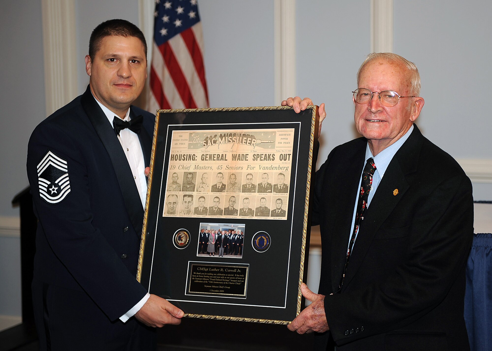 Chief Master Sgt. Michael Garrou, 4th Mission Support Group superintendent, presents an original newspaper clip from Vandenberg Air Force Base, Calif., recognizing Luther Carroll's promotion to chief master sergeant during the Enlisted Heritage Banquet on Seymour Johnson Air Force Base, N.C., Dec. 1, 2009. Mr. Carroll was one of 620 master sergeants to receive the promotion of chief master sergeant on Dec. 1, 1959, the group later became known as the Charter Chiefs. (U.S. Air Force photo/Senior Airman Ciara Wymbs) 