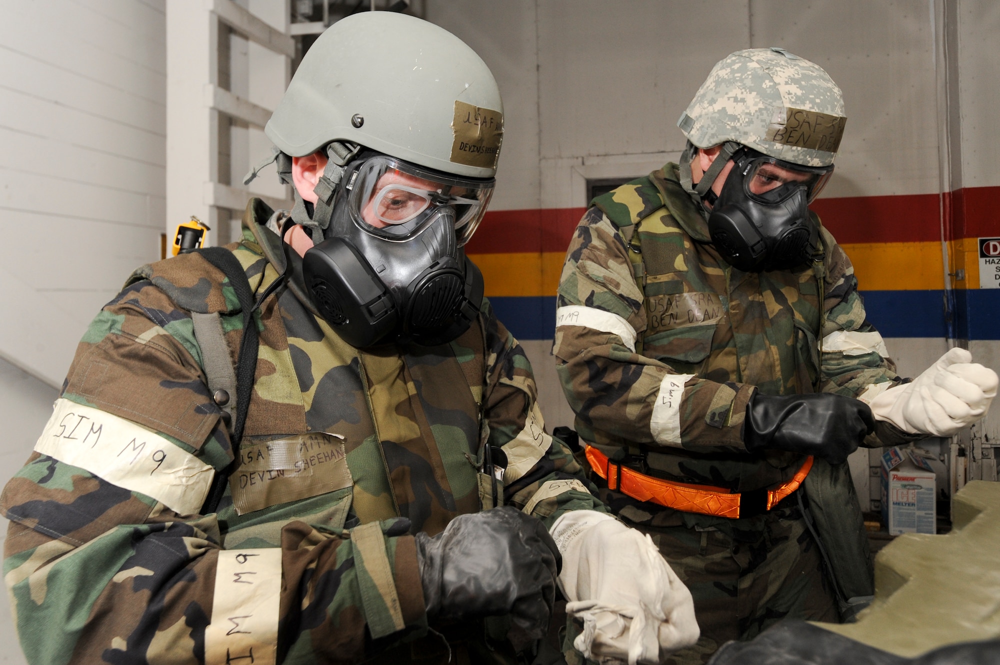 ELMENDORF AIR FORCE BASE, Alaska -- Airman Devin Sheehan (left) and Senior Airman Benjamin Dean, both from the 3rd Component Maintenance Squadron, don Mission Oriented Protective Posture 4 gear during a chemical attack for the base wide exercise, Polar Force 10-1 Dec. 3. The exercise is made up of a variety of scenarios that test the Arctic Warriors ability to handle real world situations. (U.S. Air Force photo/ Staff Sgt. Joshua Garcia)