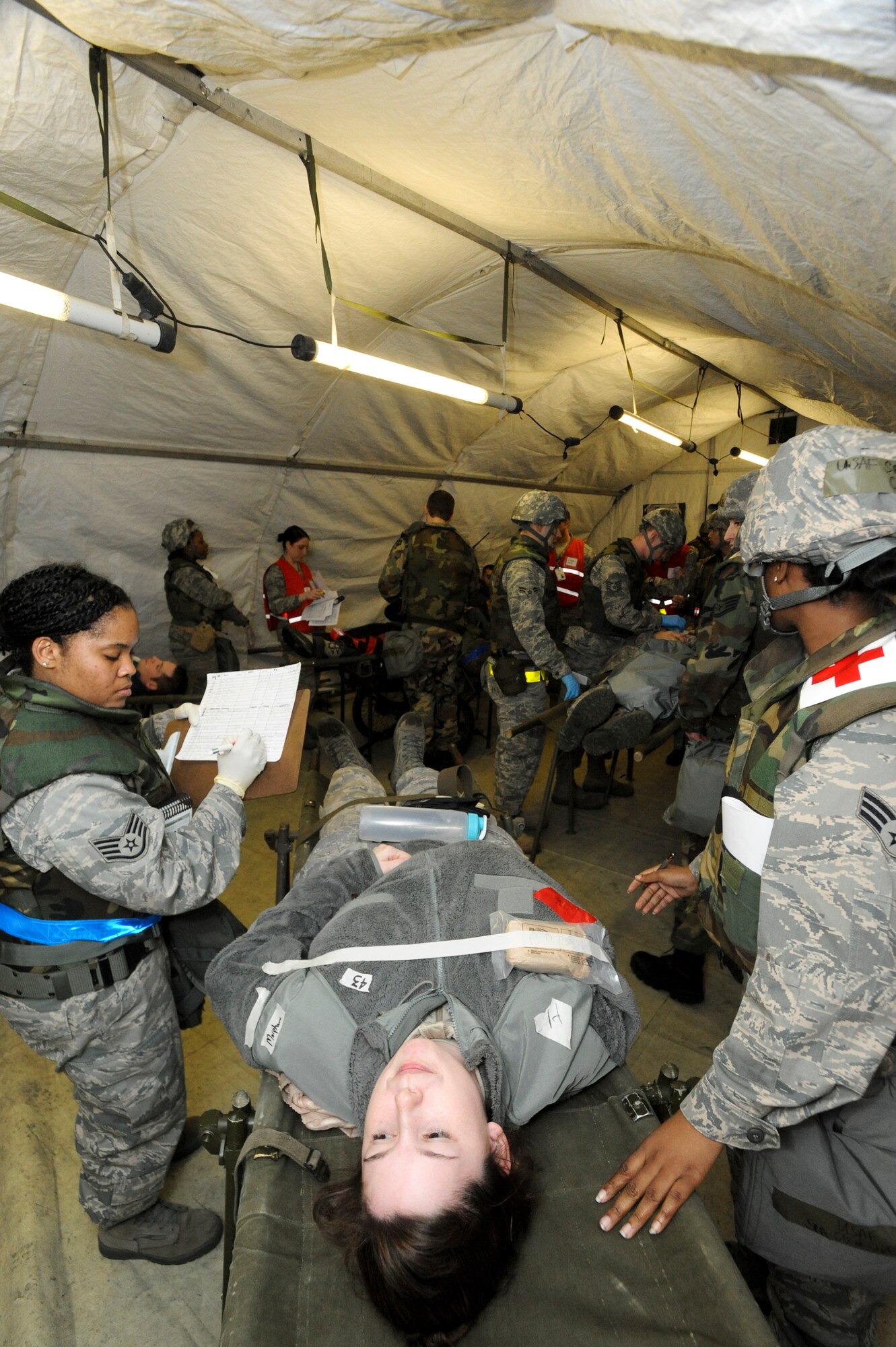 ELMENDORF AIR FORCE BASE, Alaska -- Senior Airman Jennifer Rolfe, 3rd Civil Engineer Squadron, plays a victim as medical personnel from the 3rd Medical Group diagnose and treat her conditions  during a mass casualty inject for the base-wide exercise, Polar Force 10-1 Dec. 3. The exercise is made up of a variety of scenarios that test the Arctic Warriors ability to handle real world situations. (U.S. Air Force photo/ Staff Sgt. Joshua Garcia)