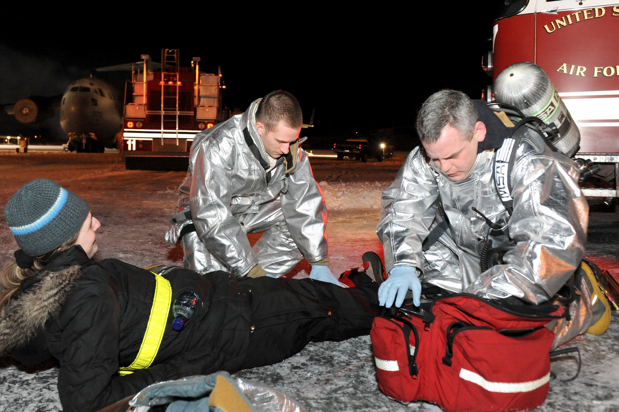 ELMENDORF AIR FORCE BASE, Alaska -- Airman Justin Davis and Tech. Sergeant Eric Graham, both fire fighters with the 3rd Civil Engineer Squadron, perform self aid buddy care to Senior Airman Jaclyn Forbes, 3rd Equipment Maintenance Squadron, simulated a victim during a mass casualty inject for the base-wide exercise, Polar Force 10-1 Dec. 3. The exercise is made up of a variety of scenarios that test the Arctic Warriors ability to handle real world situations. (U.S. Air Force photo/ Staff Sgt. Joshua Garcia)