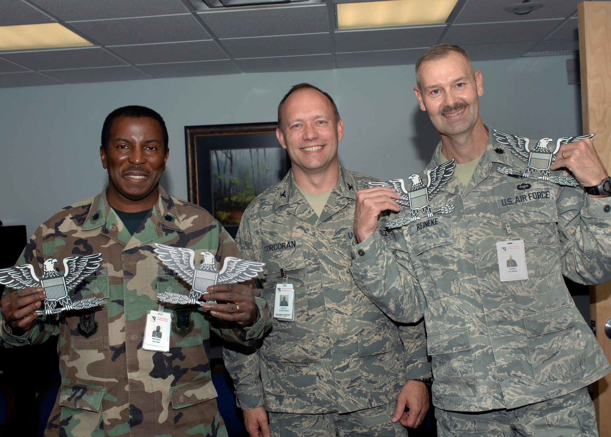 CANNON AIR FORCE BASE N.M.-- (Left) Lt. Col. Michael Fulton and Lt. Col. James
Reineke (far right) hold up colonel wings presented to them by Col. Scott
Corcoran, 27th Special Operations Medical Group commander (middle) who
notified them of their selection to colonel at the base clinic Dec. 2. Lt. Col.
Fulton, 27th Special Operations Aerospace Medicine Squadron Dental Flight
commander, was one of the 55.6% dental corps colonel selectees and Lt. Col. Reineke, 27th Special Operations Medical Operations Squadron
commander, was one of the 41.14% selected for colonel in the nurses corps. (U.S. Air Force photo by Senior Airmen James Bell)
