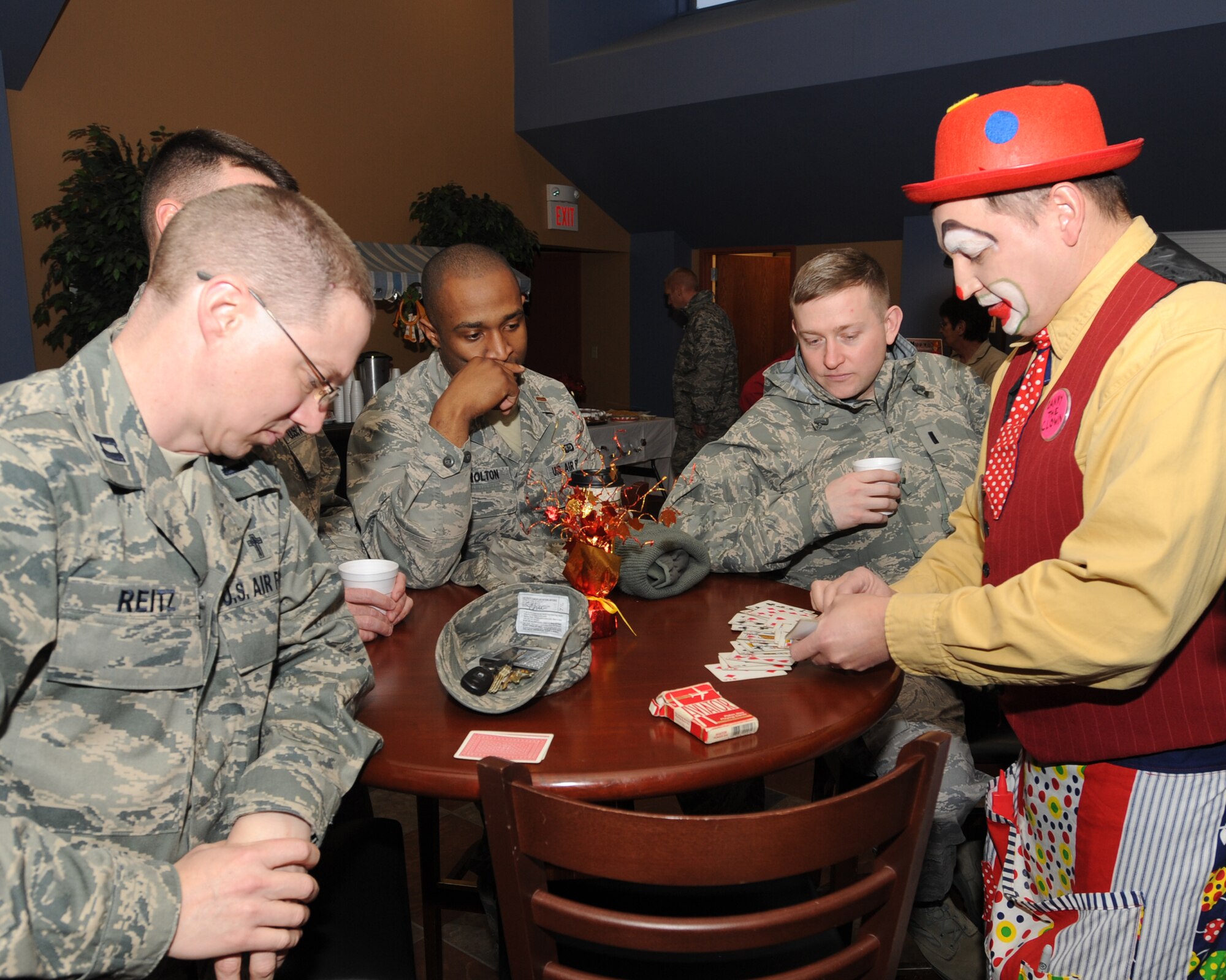 Danny the clown performs a card trick for Airmen Dec. 1 at the Community Activity Center before the base’s annual tree lighting ceremony. In addition to boosting morale, the ceremony marks the beginning of the holiday season. (U.S. Air Force photo by Staff Sgt. Suellyn F. Nuckolls)