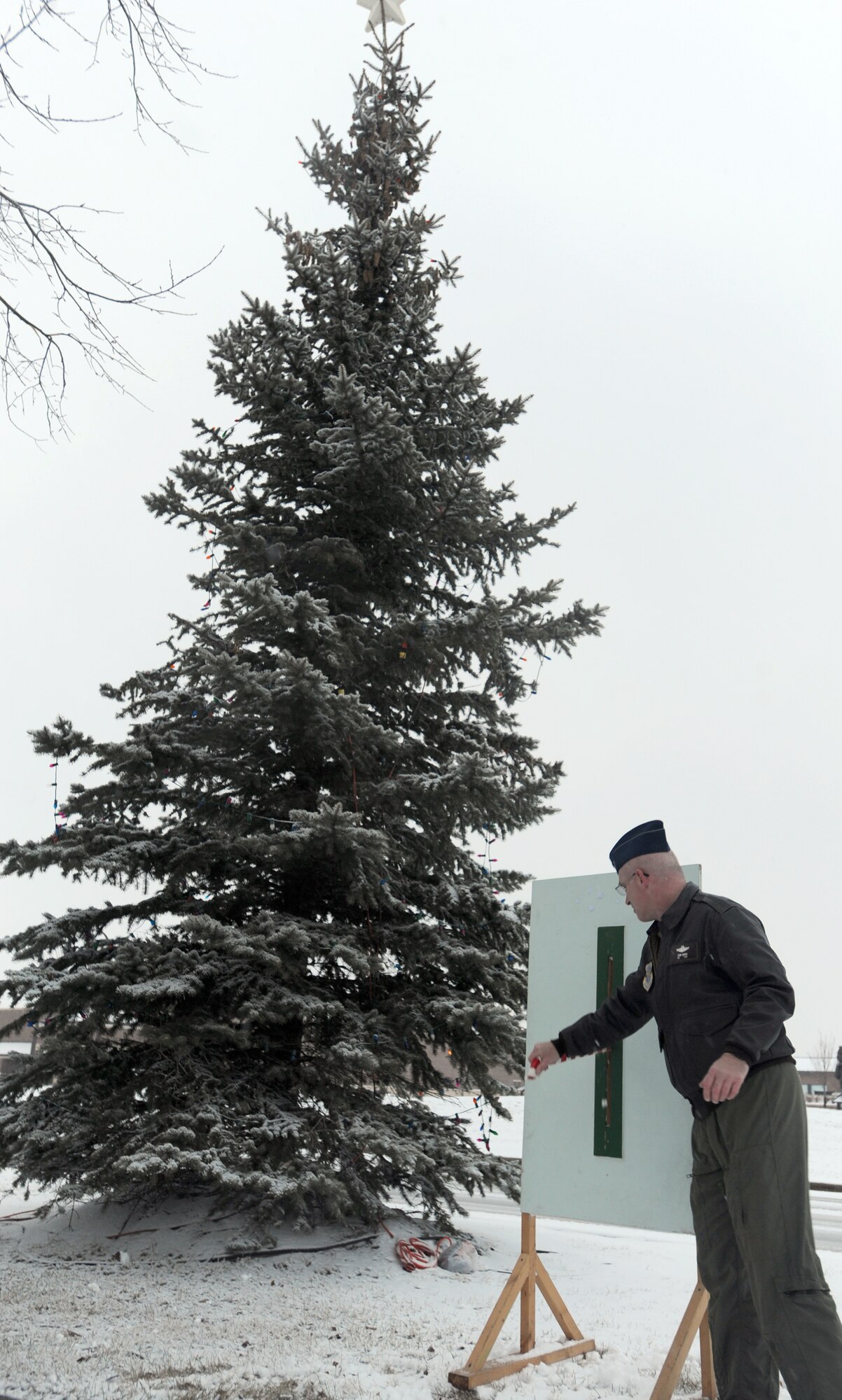 Col. John Quinn, 319th Air Refueling Wing vice-commander, flips a switch to light a tree in front of the base’s theater Dec. 1 during the annual tree light ceremony. In addition to boosting morale, the ceremony marks the beginning of the holiday season. (U.S. Air Force photo by Staff Sgt. Suellyn F. Nuckolls)
