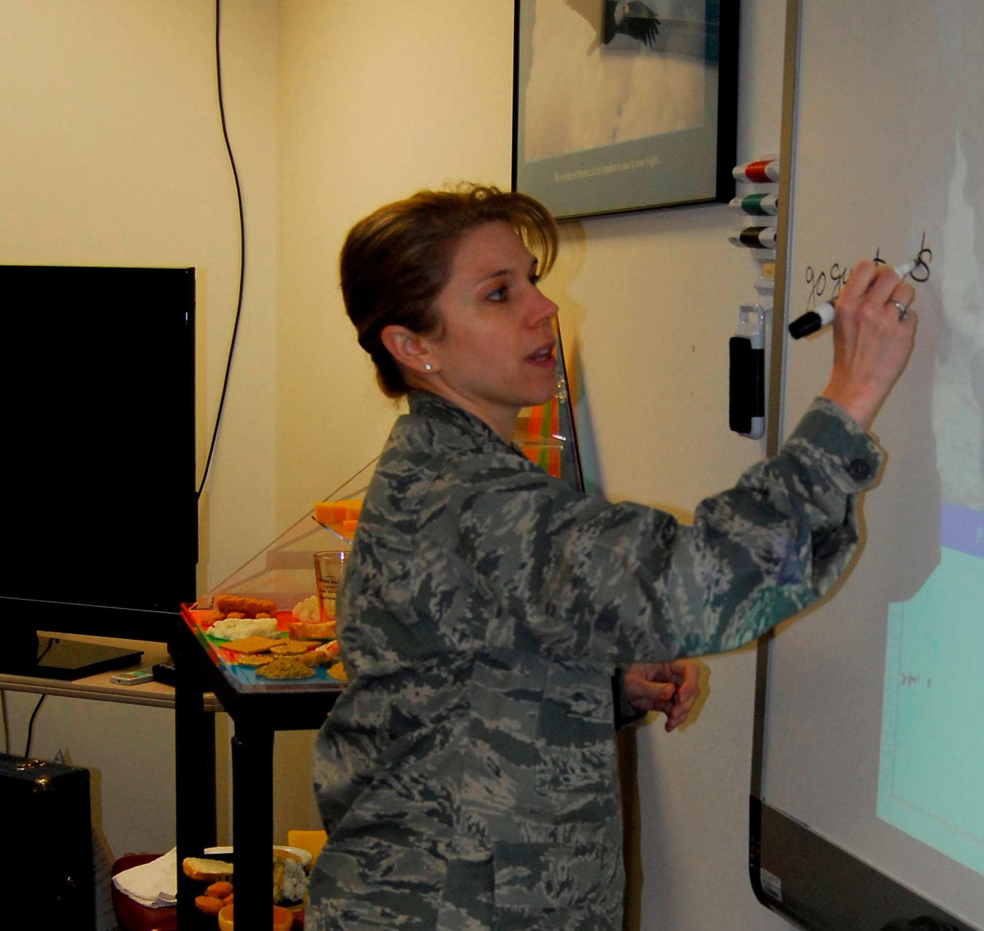 Maj. Theresa Hughes, 43rd Medical Operations Squadron, demonstrates how easy it is to eat healthy food for less during the weekly body composition improvement classes at the Health and Wellness Center. (U.S. Air Force photo by 2nd Lt. Cammie Quinn)