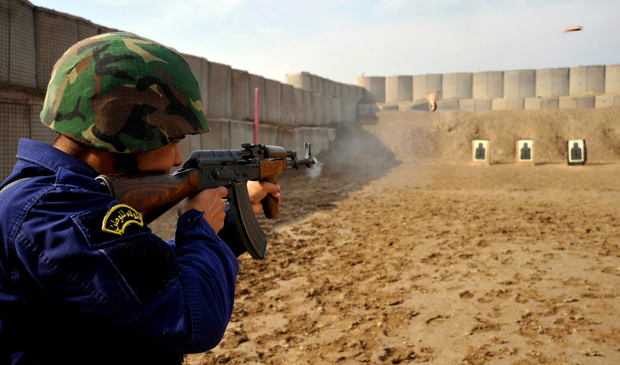 An Iraqi police officer shoots downrange at his target after recieving instructions from Staff Sgt. Michael Gomez  Nov. 21, 2009, in Baghdad, Iraq. Sergeant Gomez is assigned to the 732nd Expeditionary Security Forces Squadron Det. 2. (U.S. Air Force photo/Staff Sgt. Angelita Lawrence)