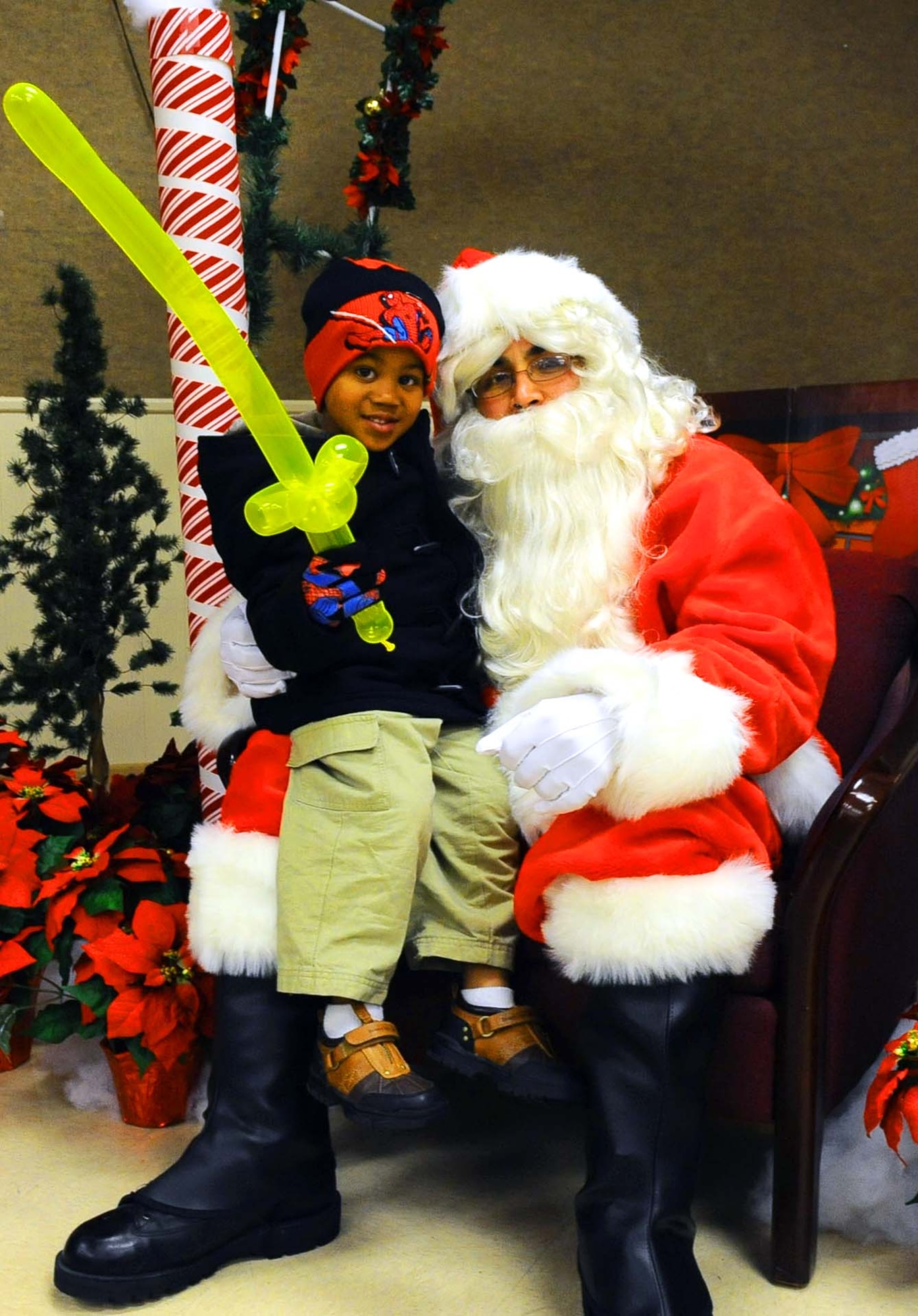 DYESS AIR FORCE BASE, Texas -- Three-year-old Dacien Owens sits on Santa’s lap during the Christmas tree and Menorah lighting at the base chapel here Dec.1.  The chapel staff hosts this event for the Dyess community with an array of guest speakers, refreshments and activities for the children. (U.S. Air Force photo by Senior Airman Domonique Washington)