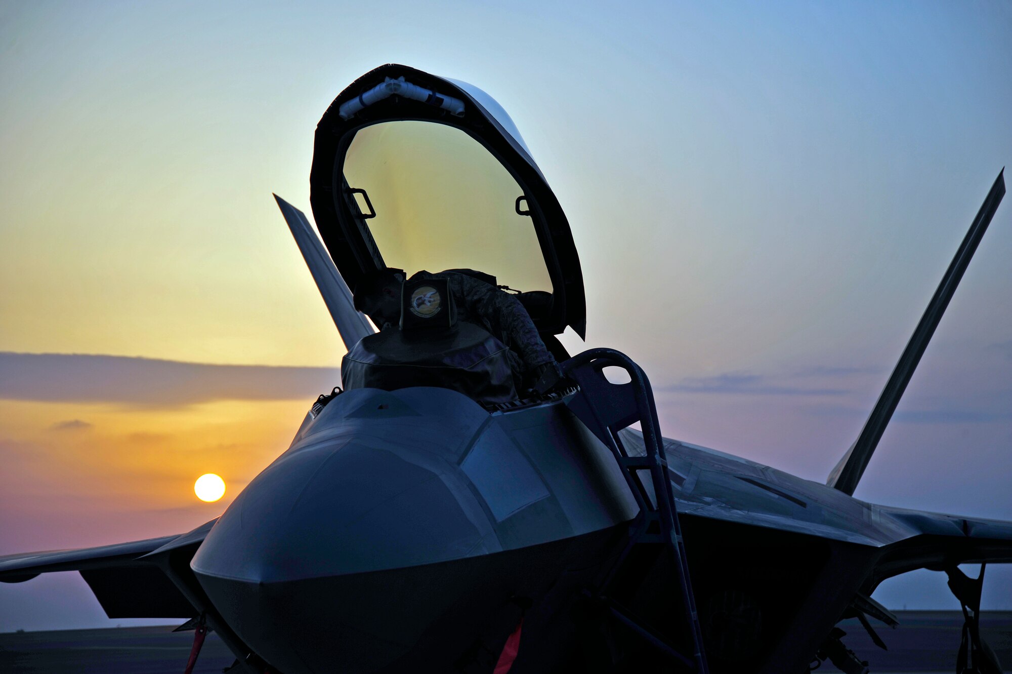 UNITED ARAB EMIRATES AIR WARFARE CENTER, UAE - The sun sets behind an F-22 Raptor Dec. 1, 2009. F-22 Raptors have deployed from the 1st Fighter Wing at Langley AFB, VA to the United Arab Emirates Air Warfare Center.  Aircrews have been participating in bilateral training opportunities with Coalition partners.  The exercises are designed to promote security, stability and mutual interests in the region.  (U.S. Air Force photo/Tech. Sgt. Charles Larkin Sr)