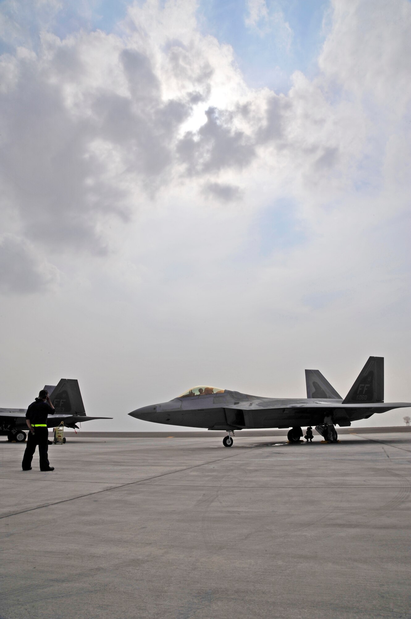 UNITED ARAB EMIRATES AIR WARFARE CENTER, UAE - Senior Airman Adam Smith, 1st Fighter Wing crew chief, prepares to marshal an F-22 Raptor piloted by Capt. Matthew Howard, 1st Fighter Wing Nov. 30, 2009. Airman Smith and Captain Howard are on temporary duty from Langley Air Force Base, Va. Airman Smith hails from Boston, Mass. Captain Howard hails from Warrensburg, Mo. F-22 Raptors have deployed from the 1st Fighter Wing at Langley AFB, VA to the United Arab Emirates Air Warfare Center.  Aircrews have been participating in bilateral training opportunities with Coalition partners.  The exercises are designed to promote security, stability and mutual interests in the region.(U.S. Air Force photo/Tech. Sgt. Charles Larkin Sr)