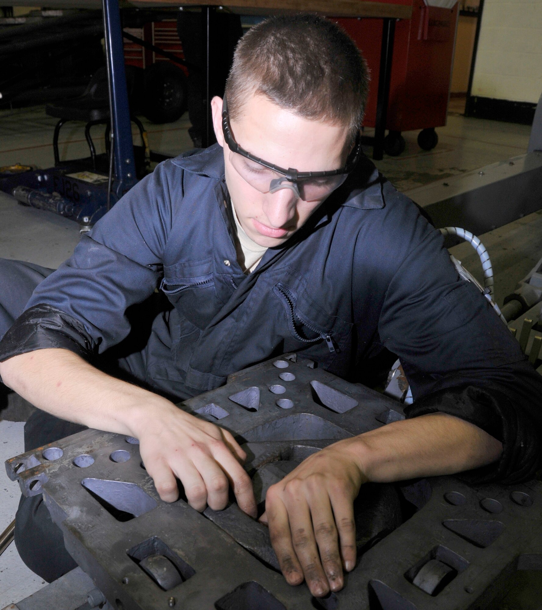 Airman 1st Class Jake Kendall, 48th Equipment Maintenance Squadron Aerospace Ground Equipment apprentice, tightens a zerk fitting for a bomb carrier table at the AGE shop Nov on RAF Lakenheath, England, Nov. 24.  AGE repairs and maintains more than 730 different parts used base wide. (U.S. Air Force photo/Airman 1st Class Eboni Knox)