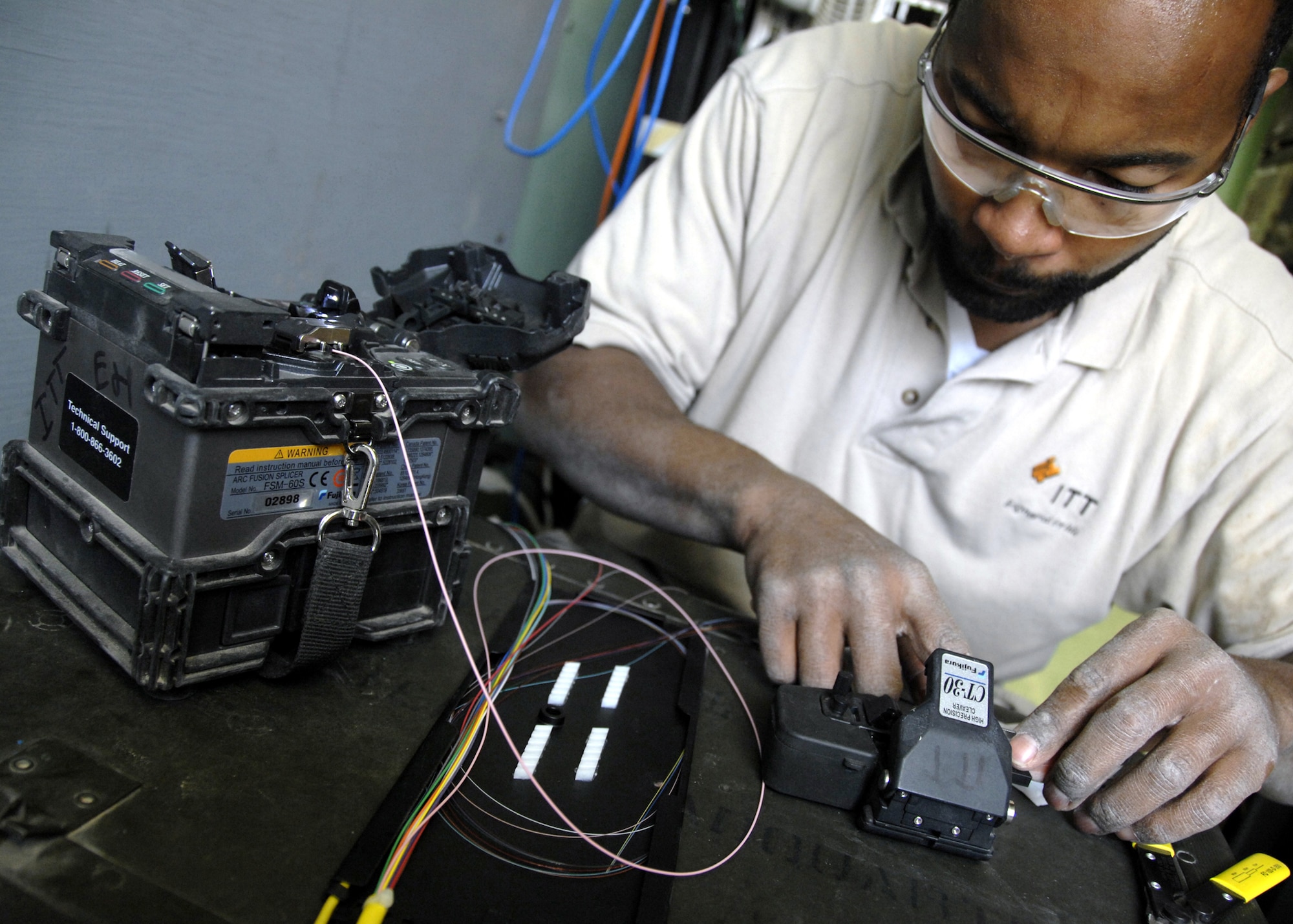 KANDAHAR AIRFIELD, Afghanistan - Ramon Arceneaux evenly cuts the end of a fiber optic wire in preparation to fuse two ends together here Nov. 28. Mr. Arceneaux is an International Telegraph Telephone contractor with the 451st Expeditionary Communications Squadron. (U.S. Air Force photo/Senior Airman Timothy Taylor)
