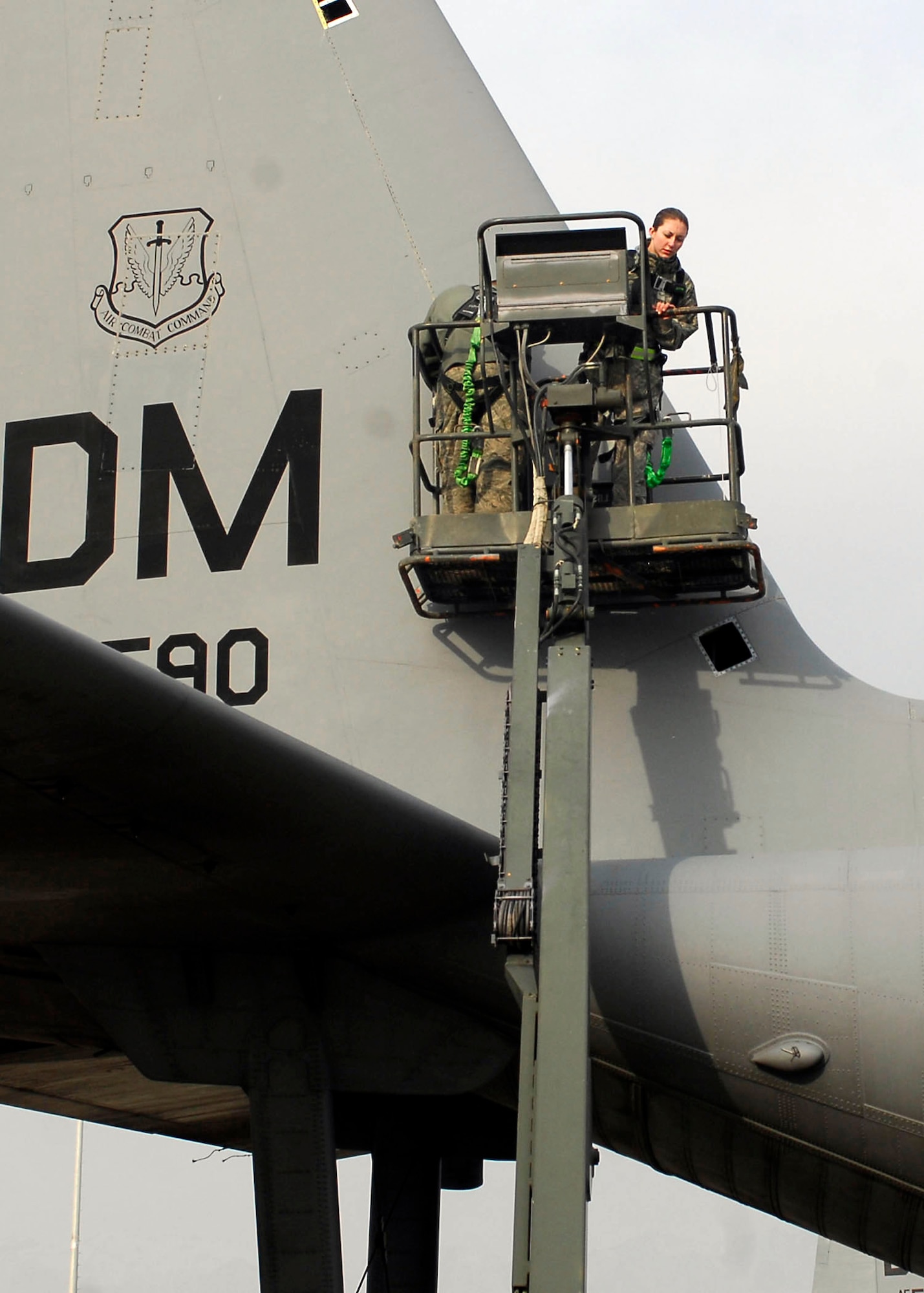 BAGRAM AIRFIELD, Afghanistan -- Airman First Class Sarah Garrett, an electronic warfare specialist from the 41st Expeditionary Electronic Combat Squadron, lowers herself and another Airman to the ground after inspecting the EC-130 Compass Call Dec. 3, 2009.  The Compass Call system employs offensive capabilities in support of U.S. and Coalition tactical air, surface, and special operations forces.  Airman Garrett is deployed from Davis-Monthan Air Force Base, Ariz., and hails from Alamogordo, N.M.  (U.S. Air Force photo/Senior Airman Felicia Juenke)
