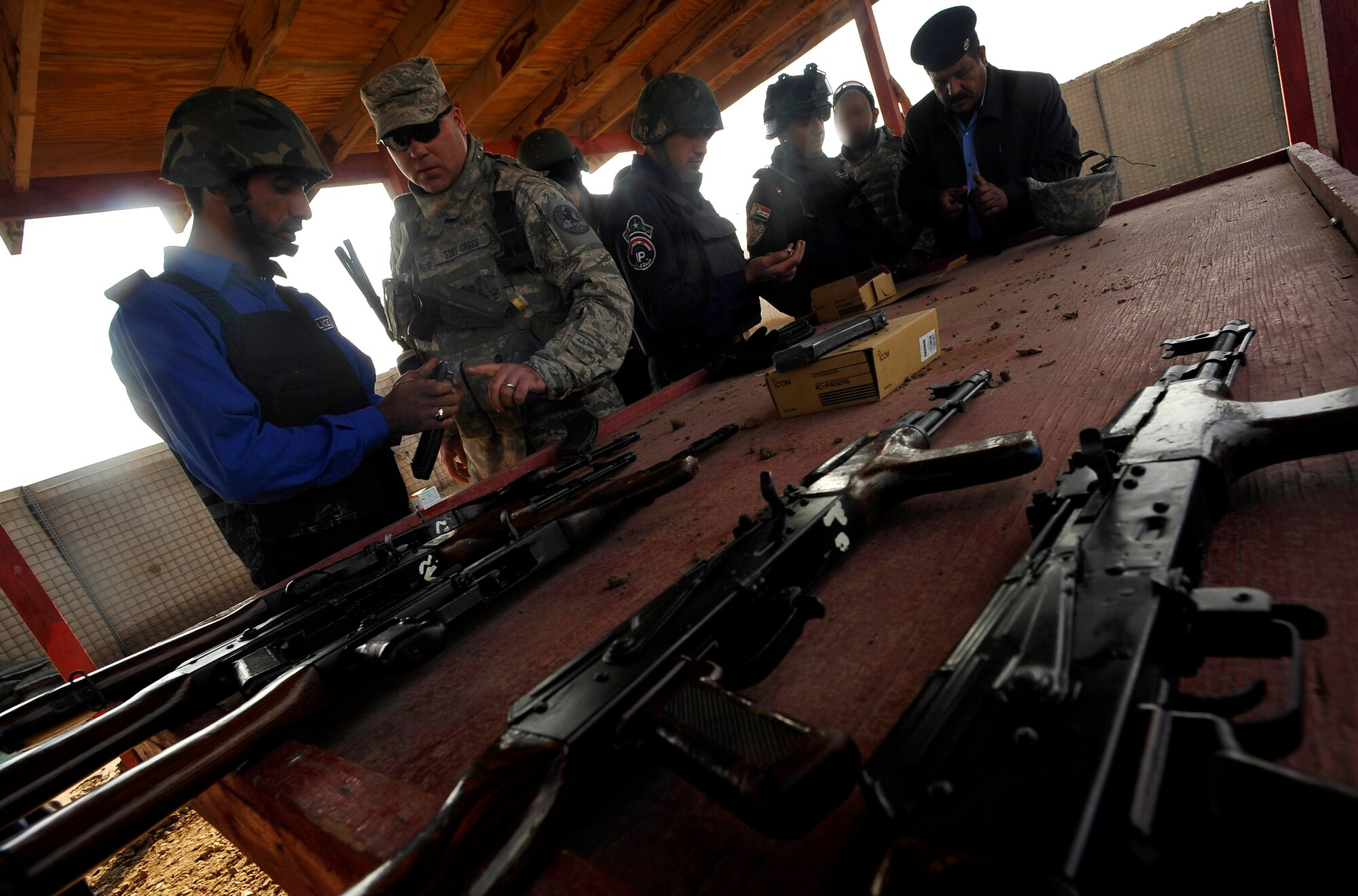U.S. Air Force Staff Sgt. Timothy Cross, a Defender assigned to the 732nd Expeditionary Security Forces Squadron Det 2, deployed to Baghdad, Iraq, mentors an Iraqi Police (IP) officer at a firing range, Nov. 18, 2009. (U.S. Air Force photo/Staff Sgt. Angelita Lawrence)
