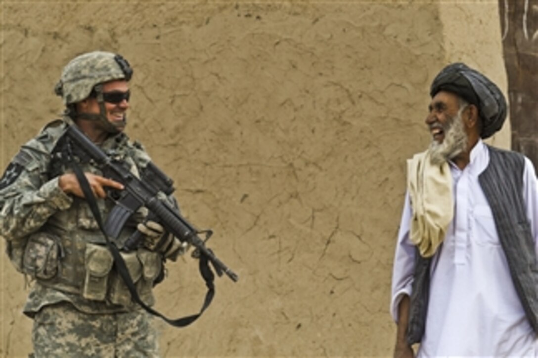 U.S. Army Spc. Steven Alexander, of Alpha Company, 422nd Civil Affairs Task Force Lobo, talks to an Afghan elder during a dismounted patrol in the village of Shabila Kalan in Zabul province, Afghanistan, on Nov. 30, 2009.  