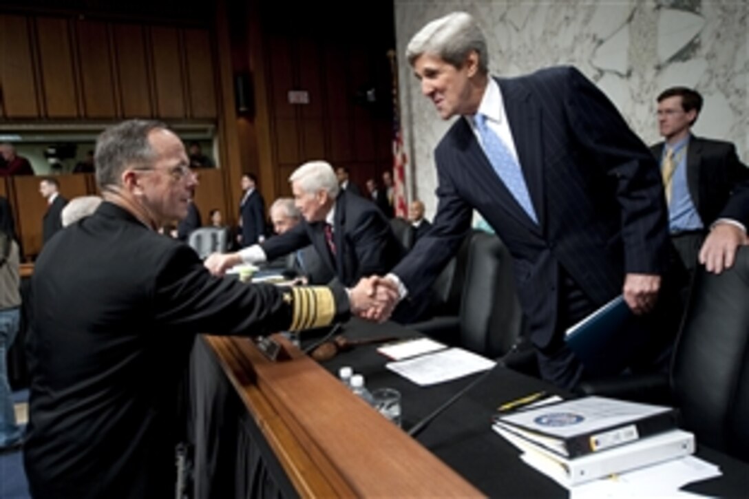 Navy Adm. Mike Mullen, chairman of the Joint Chiefs of Staff, greets Sen. John Kerry, D-Mass., chairman of the Senate Foreign Relations Committee,  before his tesimony at the Hart Senate Office Building in Washington, D.C., Dec. 3, 2009. The testimony focused on President Barack Obama's decision to send an additional 30,000 troops to the war in Afghanistan.