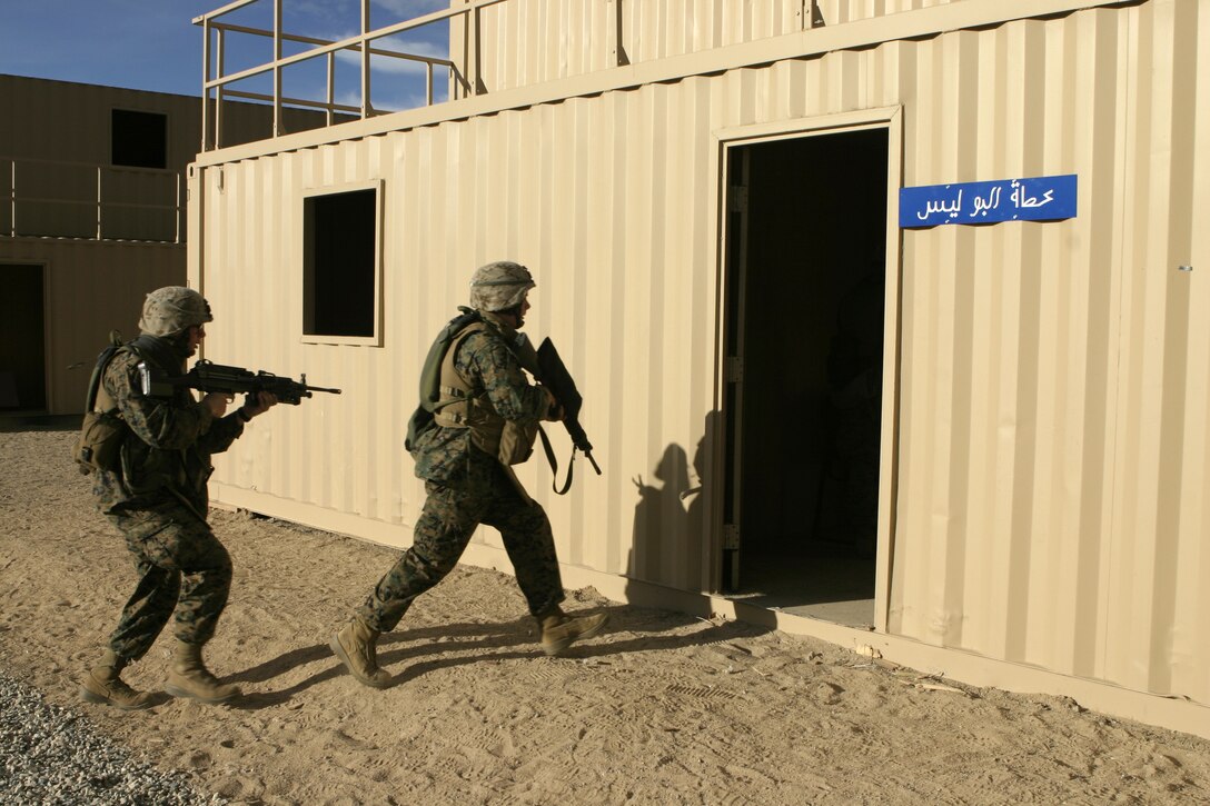 MARINE CORPS AIR-GROUND COMBAT CENTER TWENTYNINE PALMS, Calif. - Two Marines with Company A, 1st Battalion, 6th Marine Regiment prepare to enter a building at the Military Operations in Urban Terrain facility here.  The unit practiced room-clearing maneuvers to prepare for an upcoming deployment to Iraq in March.