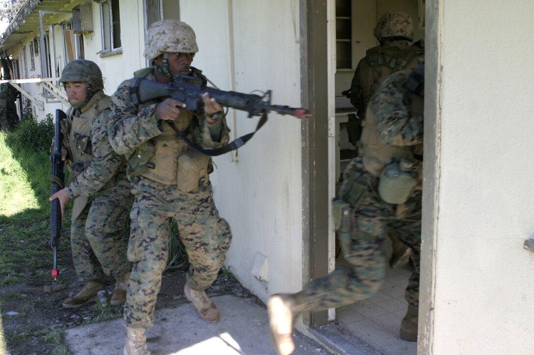 MARCH AIR RESERVE BASE, Calif. - Marines with Headquarters and Service Company, 1st Battalion, 6th Marine Regiment rush into a house aboard Matilda village here and prepare to clear it of insurgents.  The unit is conducting Security and Stabilization Operations training to prepare for a deployment to Iraq in March.