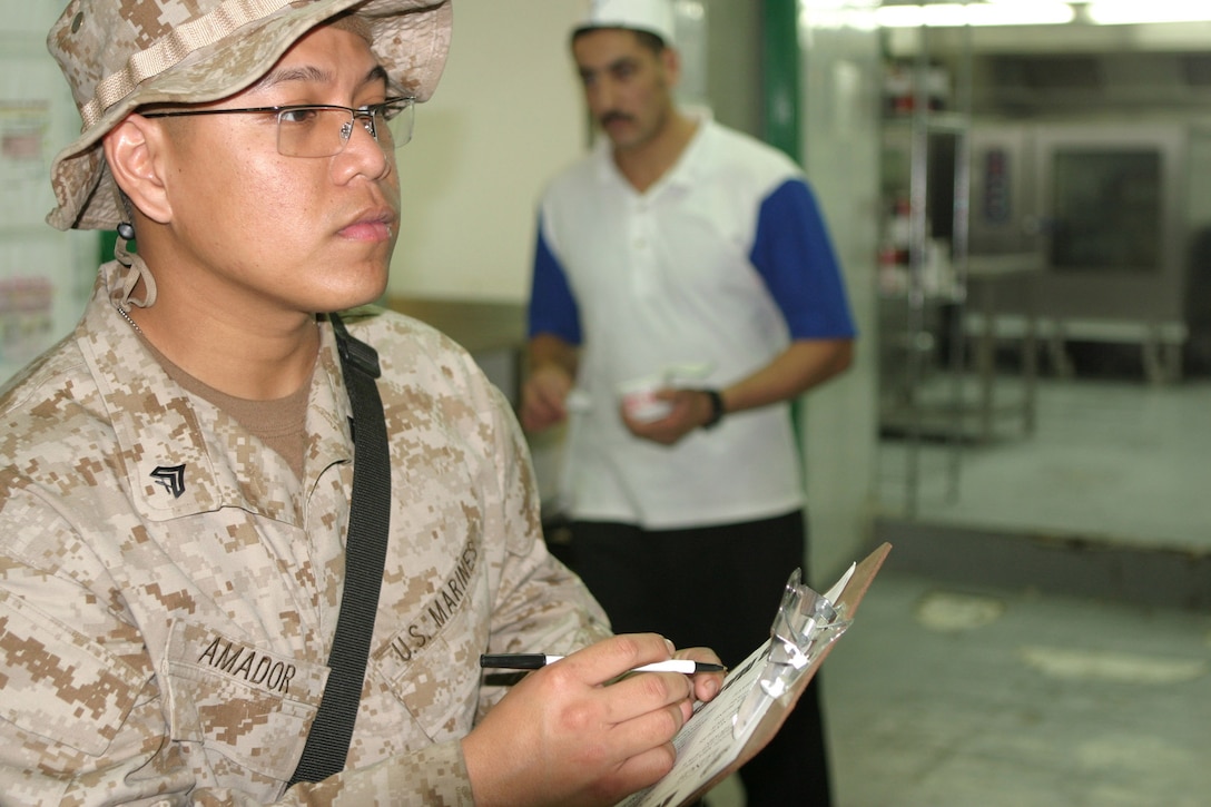 Corporal Ryan Amador, a 22-year-old food services specialist with Headquarters Battalion, 2d Marine Division, makes an inspection of the mess hall's food storage units, March 8, 2005.  Amador's unit recently deployed here for stability and security operations as part of the Global War on Terrorism.  U.S. Marine Corps photo by Sgt. Stephen D'Alessio (RELEASED)