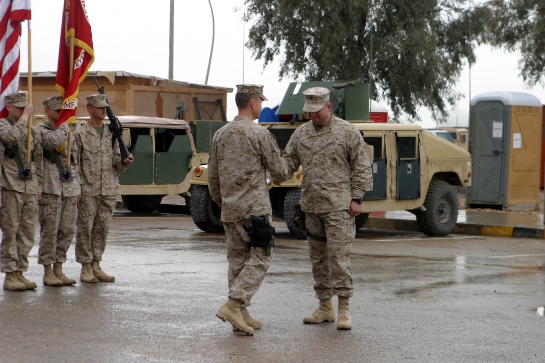 CAMP AL QAIM, IRAQ (March 9, 2005)- Lt. Col. Timothy S. Mundy (left), commanding officer of 3rd Battalion, 2d Marine Regiment and Lt. Col. Christopher Woodridge (right), commanding officer of 1st Battalion, 7th Marine Regiment shake hands to signify the passing of command during a Ceremony here March 9. The ceremony officially marked Marines of 3rd Battalion, 2d Marines assuming control of the region around Al Qaim from 1st Battalion, 7th Marines after their successful seven-month tour. Official U. S. Marine Corps photo by Lance Cpl. Christopher G. Graham (RELEASED)