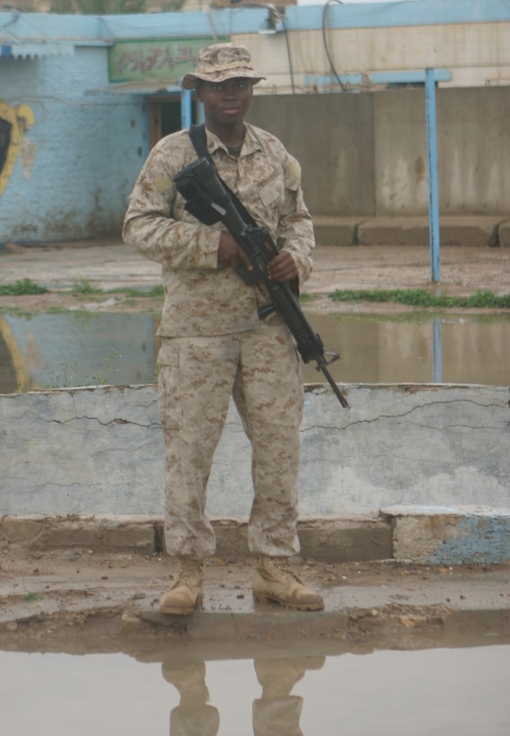 CAMP ABU GHURAYB, IRAQ – Sergeant Winston T. Daley, a Bridgeport, Conn., native, stands next to the flooded area, where one day before was dry and dusty.  Daley and his squad patrolled in Nasser Wa Saalam despite the mud and rain.  Official U.S. Marine Corps Photo by Lance Cpl. Athanasios L. Genos.