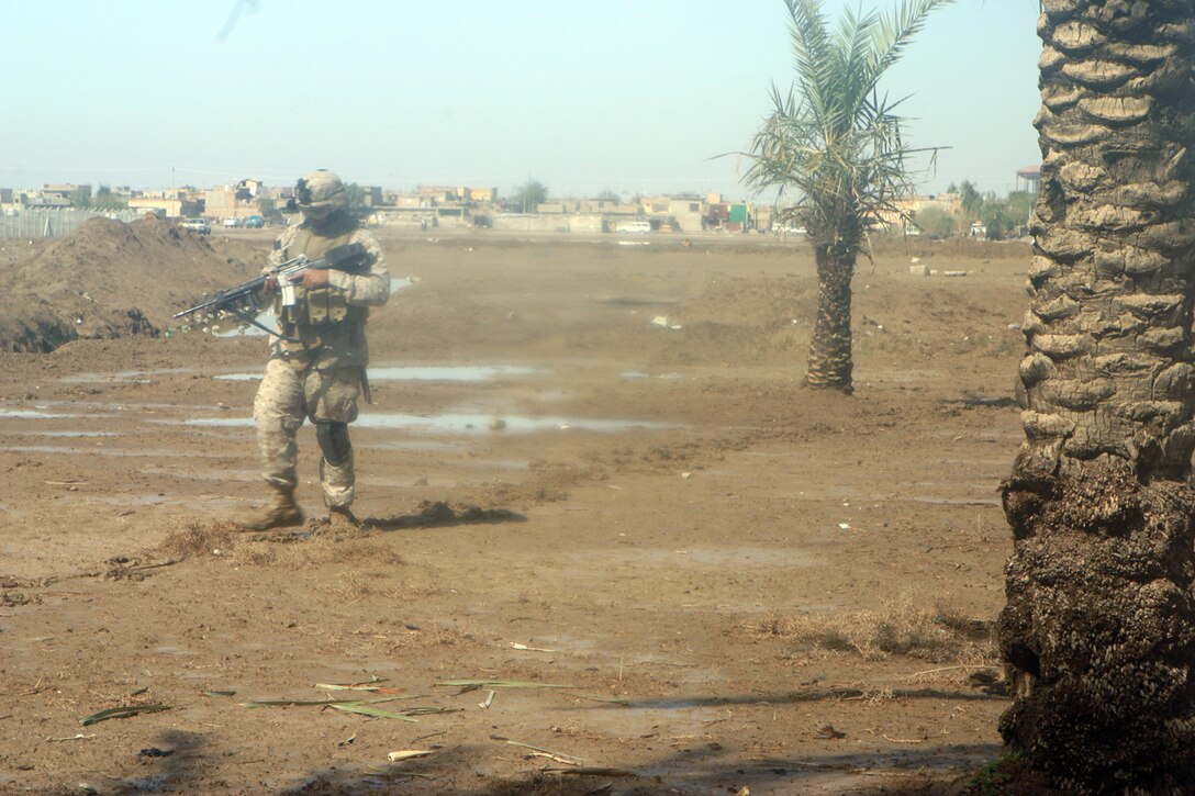 CAMP ABU GHURAYB, IRAQ --  Lance Cpl. Amarinder Grewal, a Sterling Heights, Mich., native, patrols through the muddy grounds in Nasser Wa Saalam.  Along with his fellow Marines, Grewal did not let the effects of nature stop him from doing his job.  Official US Marine Corps photo by Lance Cpl. Athanasios Genos.