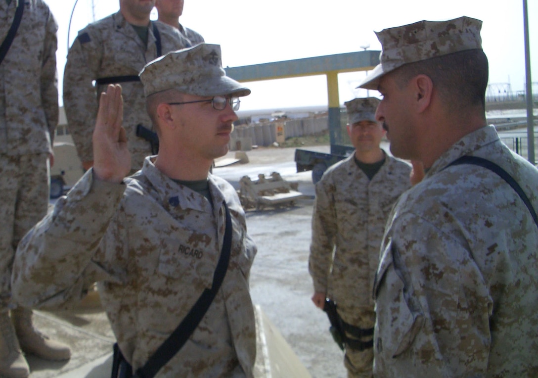 CAMP AL QAIM, Iraq (March 12, 2005)- Staff Sgt. Benjamin Ricard, the battalion training chief for 3rd Battalion, 2d Marine Regiment reenlists by Gunner Nick Vitale, the battalion gunner, with his fellow Marines behind him. The Cartersville, Ga., native joined the Marine Corps in 1994 because he wanted the Corps to make a man out of him. This is his first deployment to Iraq. Official U.S. Marine Corps photo by Lance Cpl. Lucian Friel (RELEASED)