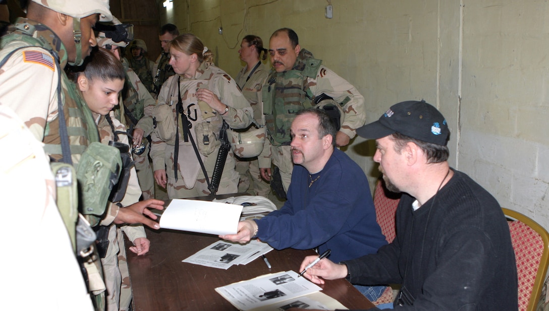 CAMP ABU GHURAYB, IRAQ -- Comedians Jim McCue and Joey Carroll signed autographs after their acts for the Marines, Army, Air Force and Navy personnel at Camp Abu Ghurayb.  The comedians traveled all around the world visiting servicemembers.  Official U.S. Marine Corps photo by Lance Cpl. Athanasios Genos