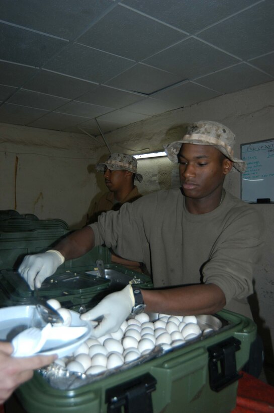 HURRICANE POINT, Ar Ramadi, Iraq (March 13, 2005) - Eighteen-year-old Pfc. Darius D. Gage, a food service specialist with Headquarters and Service Company, 1st Battalion, 5th Marine Regiment, serves a hungry devil dog a spoonful of hardboiled eggs during morning chow at the mess hall here. The Chicago native modeled clothing for four years in Essence Magazine prior to joining the Marines summer of 2004. He often made more than $500 for doing 24 hours of modeling. He joined the Corps to be a part of something that makes a difference in the world. (Official United States Marine Corps photo by Cpl. Tom Sloan)