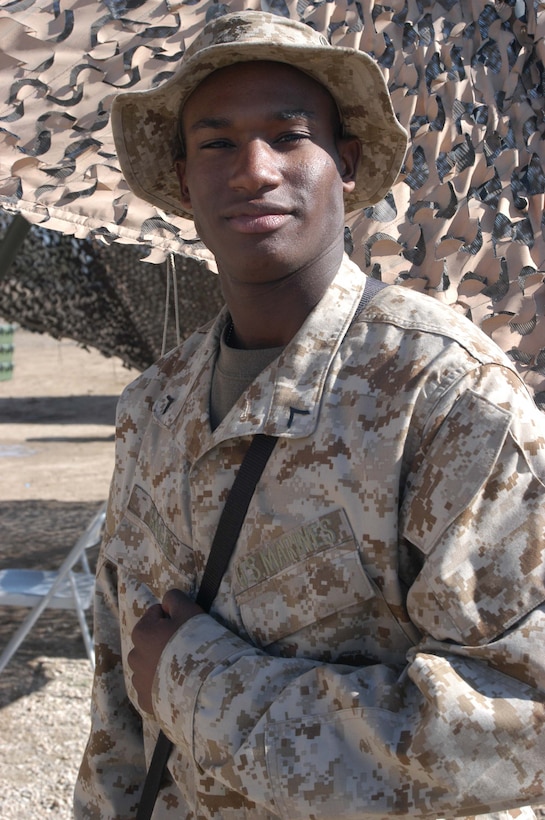 HURRICANE POINT, Ar Ramadi, Iraq (March 13, 2005) - Eighteen-year-old Pfc. Darius D. Gage, a food service specialist with Headquarters and Service Company, 1st Battalion, 5th Marine Regiment, posses for a photo outside the mess hall here. Having his picture taken is nothing new for Gage. The Chicago native modeled clothing for four years in Essence Magazine prior to joining the Marines summer of 2004. He often made more than $500 for doing 24 hours of modeling. He joined the Corps to be a part of something that makes a difference in the world. (Official United States Marine Corps photo by Cpl. Tom Sloan)