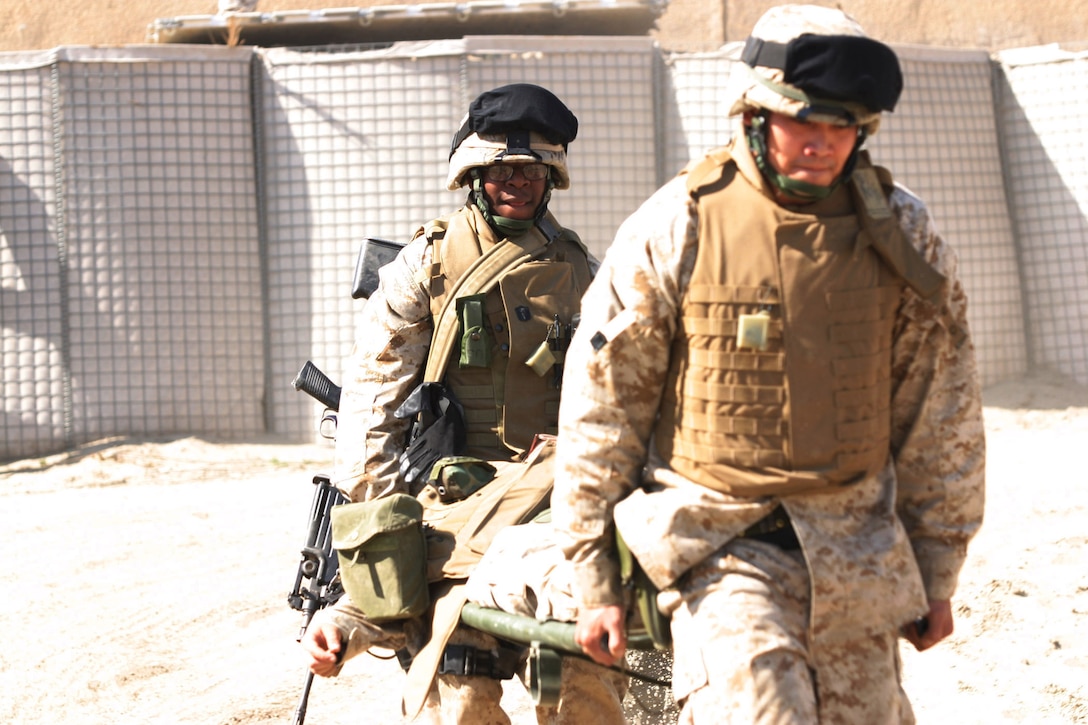 CAMP BLUE DIAMOND, AR RAMADI, Iraq -- Hospitalman Darius Evans, a 20-year-old Chicago native and 2003 George W. Collins High School graduate, and HA Michael Pacer, a 21-year-old San Diego, Calif. native and Scripps Ranch High School graduate, carries a Marine to an ambulance during one of the camp's drills.  The BAS Corpsmen are some of the first on the scene in an emergency.  U.S. Marine Corps photo by Sgt. Stephen D'Alessio (RELEASED)