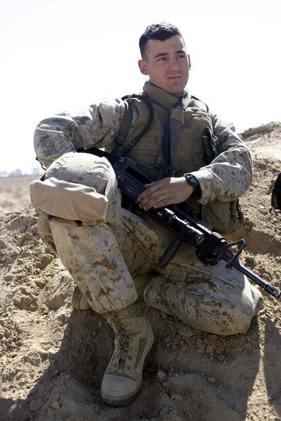 CAMP BAHARIA, Iraq - Pfc. Mitchel T. Caluri, mortarman with 3rd Combined Anti-Armor Team Platoon, Weapons Company, 1st Battalion, 6th Marine Regiment, sits atop a dirt mound as he takes a break from a rifle range his unit fired here March 18.  The Stetson, Maine native and fellow Marines and sailors are currently deployed to Iraq to conduct security and stability operations in Fallujah.