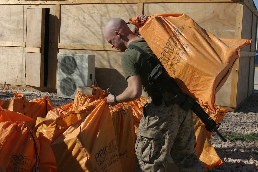 CAMP AL QA'IM, Iraq (March 17, 2005)- Lance Cpl. Bryan A. Crane, a native of Billings, Mont., moves bags of packages into the battalion mailroom. Crane, the mail clerk with 3rd Battalion, 2d Marine Regiment handles all the mail that comes to the battalion. Crane graduated from Derby High School in 2002. He joined the Marine Corps in 2004 to continue a family tradition. Official U.S. Marine Corps photo by Lance Cpl. Lucian Friel (RELEASED)
