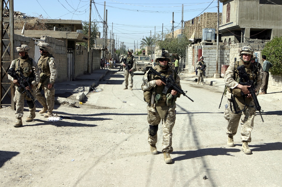 FALLUJAH, Iraq - 3rd Platoon, Company C, 1st Battalion, 6th Marine Regiment patrols through the city streets here March 21.  The unit is currently deployed here to conduct security and stability operations.