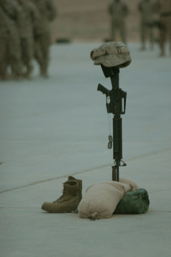 CAMP AL QA'IM, Iraq (March 22, 2005)- The Marines of 3rd Battalion, 2nd Marine Regiment honor their fallen brother Lance Cpl. Kevin Smith who was killed in action by a vehicle borne improvised explosive device March 21. The Memorial ceremony took place here March 22. The Battalion Chaplain Lt. John Anderson, along with the Marine's squad leader and platoon commander, gave a memorial speech in honor of Smith, who was with the battalion's security platoon. Official U.S. Marine Corps photo by Lance Cpl. Lucian Friel (RELEASED)