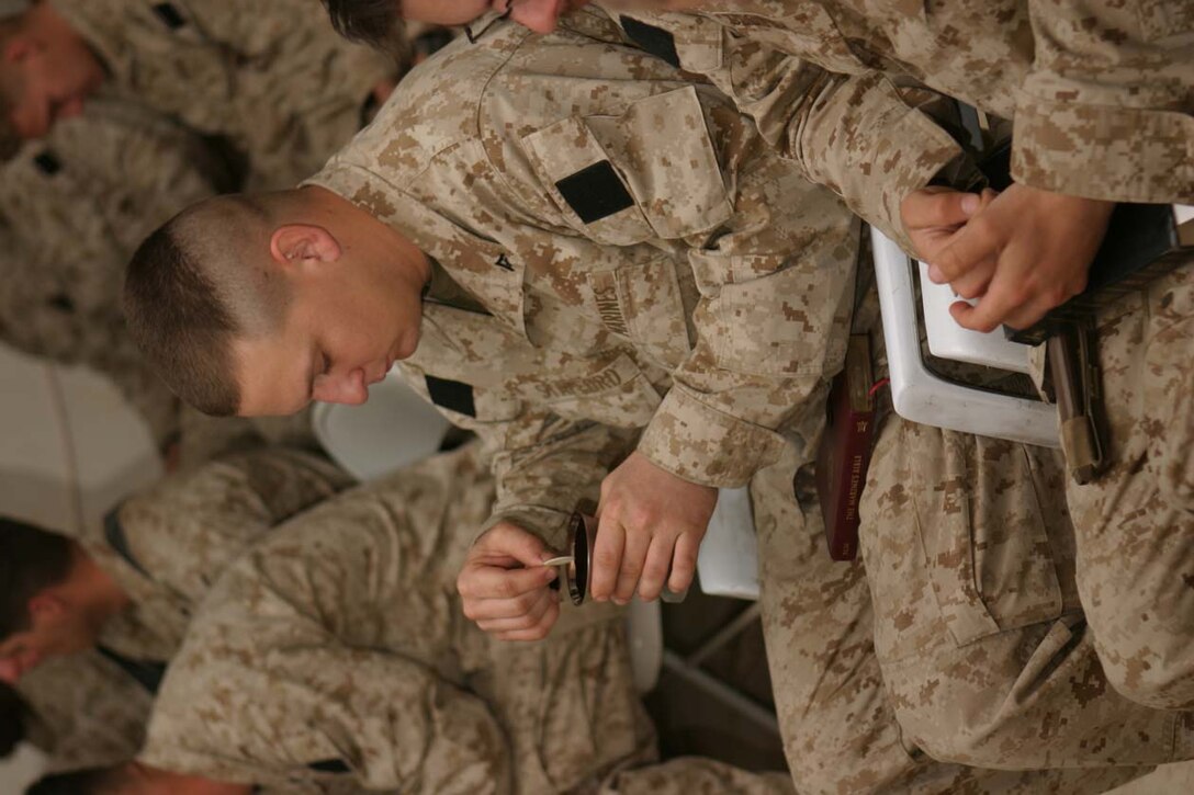 CAMP FALLUJAH, IRAQ – Marines take part in communion during the Easter Sunday service held at the battalion chapel, which was led by the Battalion Chaplain Navy Lt. Robert E. Bradshaw.  Everyone who wanted was able to take part in communion.  Official U.S. Marine Corps photo by Lance Cpl. Athanasios L. Genos