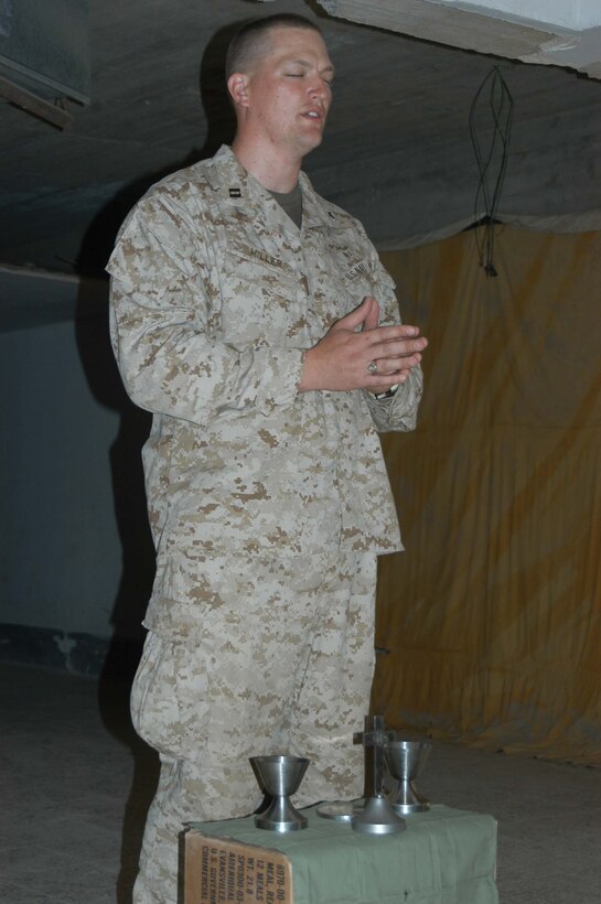 AR RAMADI, Iraq (March 27, 2005) - Navy Lt. Aaron T. Miller, chaplain for 1st Battalion, 5th Marine Regiment, prays while conducting Easter service at observation post VA here. The 32-year-old man of God from Redlands, Calif., visited Marines from the infantry battalion's five companies of whom he preached a hasty Easter service and served Holy Communion to. The effort, which lasted more than six hours, required Miller to travel to seven different places in the city where Marines are serving. Photo by Cpl. Tom Sloan