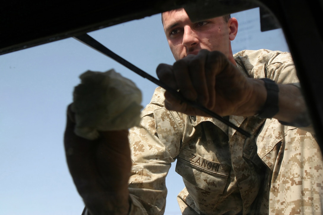 CAMP BLUE DIAMOND, AR RAMADI, Iraq -- Corporal Vincent Zanghi, a 21-year-old Stewartstown, Pa. native and motor transportation operator, wipes down the windshield of his Humvee, March 31.  The 2001 Kennard-Dale High School graduate rolls out on security convoys nearly on a daily basis.  U.S. Marine Corps photo by Sgt. Stephen D'Alessio (RELEASED)