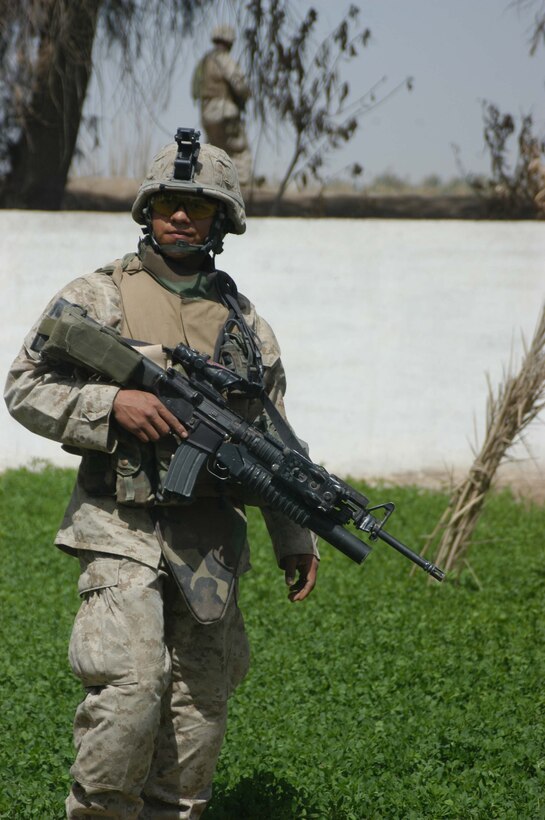 AR RAMADI, IRAQ (April 4, 2005) - Corporal Eduardo Munoz, a team leader with 1st Squad, 4th Platoon, Company B, 1st Battalion, 5th Marine Regiment, patrols an area on the edge of the city here with his fellow Marines. This is the 24-year-old Mission, Texas, native's second time in Iraq fighting the War on Terrorism, and he plans on making a career out of the Marine. He has a wife, Sonia, and four-week-old son, Eduardo Jr., waiting for him back home. Photo by Cpl. Tom Sloan