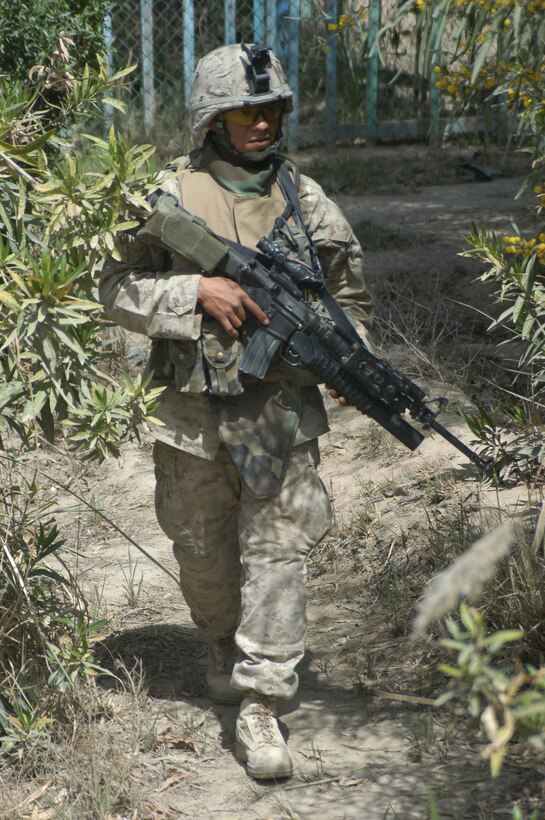 AR RAMADI, IRAQ (April 4, 2005) - Corporal Eduardo Munoz, a team leader with 1st Squad, 4th Platoon, Company B, 1st Battalion, 5th Marine Regiment, patrols an area on the edge of the city here with his fellow Marines. This is the 24-year-old Mission, Texas, native's second time in Iraq fighting the War on Terrorism, and he plans on making a career out of the Marine. He has a wife, Sonia, and four-week-old son, Eduardo Jr., waiting for him back home. Photo by Cpl. Tom Sloan