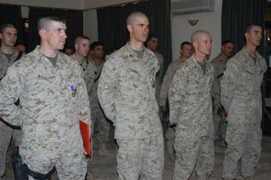 CAMP HURRICANE POINT, Ar Ramadi, Iraq (April 5, 2005) - Major Benjamin B. Busch, Sgt. David J. Oconnell, Cpl. Travis E. Box and Pfc. Andrew J. Juraska were awarded Purple Hearts at a ceremony here for wounds they received while supporting Operation Iraqi Freedom during their first month in Iraq. The four Marines' wounds were from shrapnel, and each Marine returned to full duty the next day after being injured. More than 40 of their fellow Marines, Navy officers and corpsman attended to honor the four Marines who cheated death. They now join the ranks of many servicemembers before them who've received the U.S. military's oldest medal, which was first awarded in 1782. Photo by Cpl. Tom Sloan