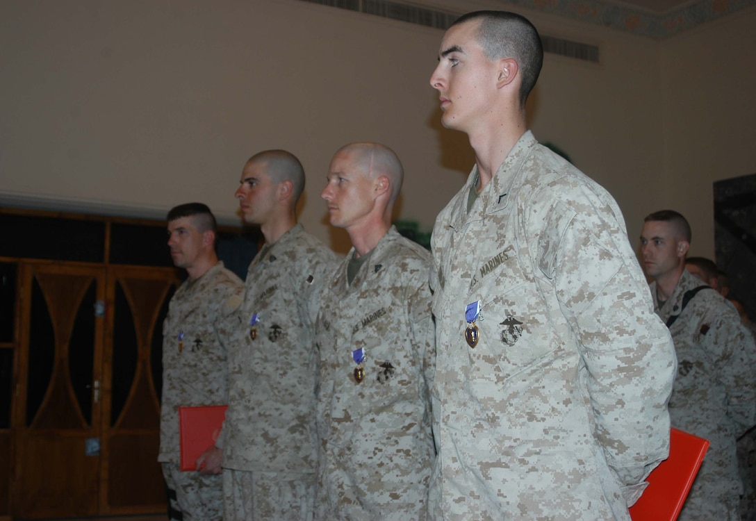 CAMP HURRICANE POINT, Ar Ramadi, Iraq (April 5, 2005) -Private First Class Andrew J. Juraska, Cpl. Travis E. Box, Sgt. David J. Oconnell and Major Benjamin B. Busch, were awarded Purple Hearts at a ceremony here for wounds they received while supporting Operation Iraqi Freedom during their first month in Iraq. The four Marines' wounds were from shrapnel, and each Marine returned to full duty the next day after being injured. More than 40 of their fellow Marines, Navy officers and corpsman attended to honor the four Marines who cheated death. They now join the ranks of many servicemembers before them who've received the U.S. military's oldest medal, which was first awarded in 1782. Photo by Cpl. Tom Sloan