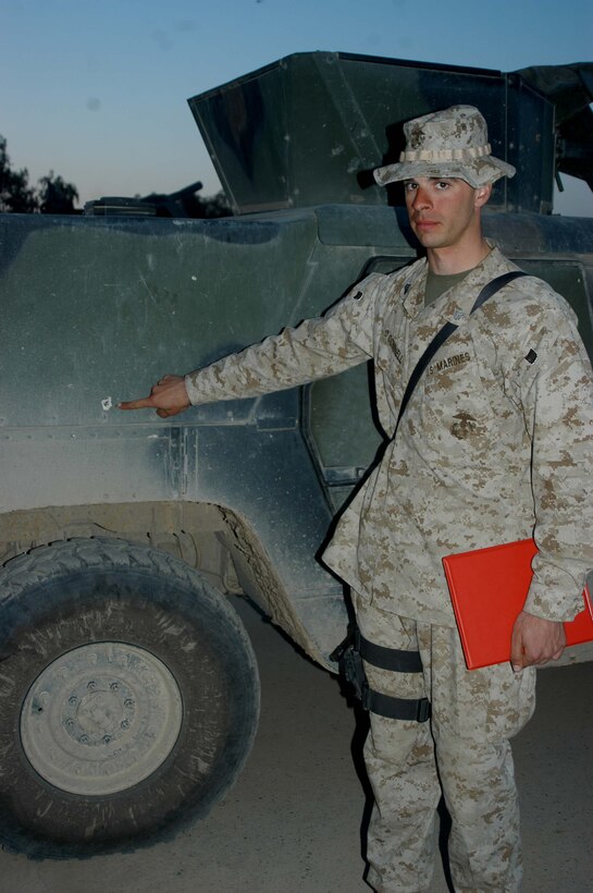 CAMP HURRICANE POINT, Ar Ramadi, Iraq (April 5, 2005) - Sergeant David J. Oconnell, machine gunner, Jump Platoon, Headquarters and Service Company, 1st Battalion, 5th Marine Regiment, points to a hole in a Humvee made by shrapnel from an improvised explosive devise. The 26-year-old from Salem, Conn., was riding the vehicle's turret two weeks ago when it hit the IED. Oconnell took shrapnel to the forehead but returned to full duty the following day after being injured. He and three other warriors with the infantry battalion were presented Purple Hearts during a ceremony here. Photo by Cpl. Tom Sloan
