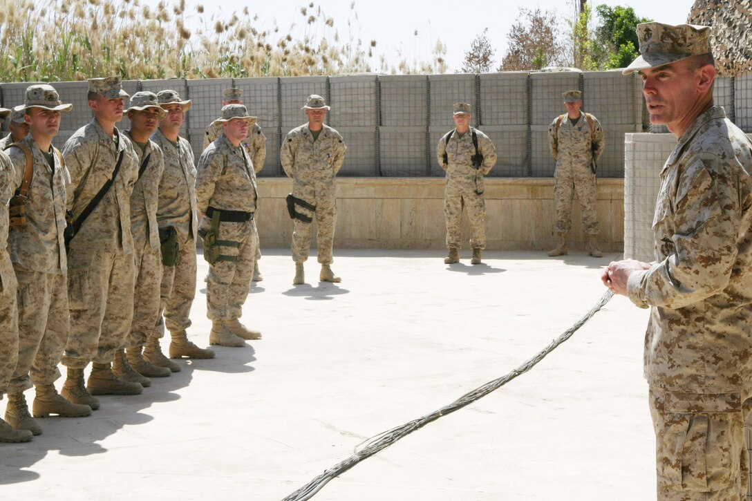 CAMP BLUE DIAMOND, Iraq - Brigadier Gen. Joseph J. McMenamin, assistant division commander for 2nd Marine Division, speaks to Marines attending a formation for Gunnery Sgt. William Easton, staff non commissioned officer-in-charge of 2nd Light Armored Reconnaissance and Cpl. Justin Harris, a 23-year-old light armored vehicle technician, receive a Purple Hearts, April 8, for injuries they received from a roadside explosion.  An improvised explosive device (IED), used by insurgents as a way to inflict collateral damage from a distance, rocked through two convoys as they passed one another in opposite directions on a dirt road near the base, March 13.  Easton, Harris and thier team were providing security on the road from within their Light Armored vehicles and Humvees.  U.S. Marine Corps photo by Sgt. Stephen D'Alessio (RELEASED)