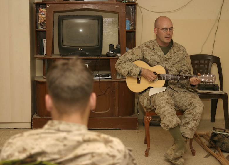 FALLUJAH, Iraq - Navy Lt. Richard Ryan, 1st Battalion, 6th Marine Regiment's chaplain, plays his guitar and leads the Marines of Company C, 1st Battalion, 6th Marine Regiment in song during worship service here April 8.  The 30-year-old Hendersonville, Tenn. native is currently deployed to Iraq, where he tends to his unit's spiritual needs and offers counseling services.