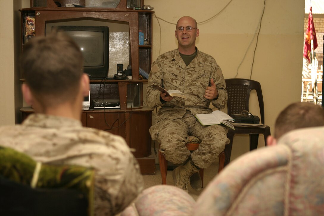 FALLUJAH, Iraq - Navy Lt. Richard Ryan, 1st Battalion, 6th Marine Regiment's chaplain, reads out of the Bible as he offers religious services here April 8 to the Marines of Company C, 1st Battalion, 6th Marine Regiment.  The 30-year-old Hendersonville, Tenn. native is currently deployed to Iraq, where he tends to his unit's spiritual needs and offers counseling services.