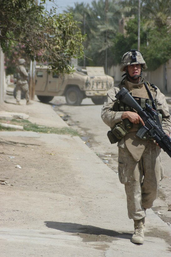 AR RAMADI, Iraq (April 11, 2005) - Lance Cpl. Matthew V. Komatz, a grenadier and the point man for 2nd Squad, 1st Platoon, Company A, 1st Battalion, 5th Marine Regiment, checks behind him to see if his fellow squad members are properly dispersed during an aggressive foot patrol through the city here. The 22-year-old Long Beach, Calif., native and his fellow leathernecks with 2nd Squad, 1st Platoon, Company A, 1st Battalion, 5th Marines, have become familiar with their area of operations where they conduct security and stability operations almost daily. They've learned to recognize landmarks to help determine what particular street they're patrolling. First Battalion, 5th Marines are two months into their seven-month deployment here in support of Operation Iraqi Freedom. Photo by Cpl. Tom Sloan