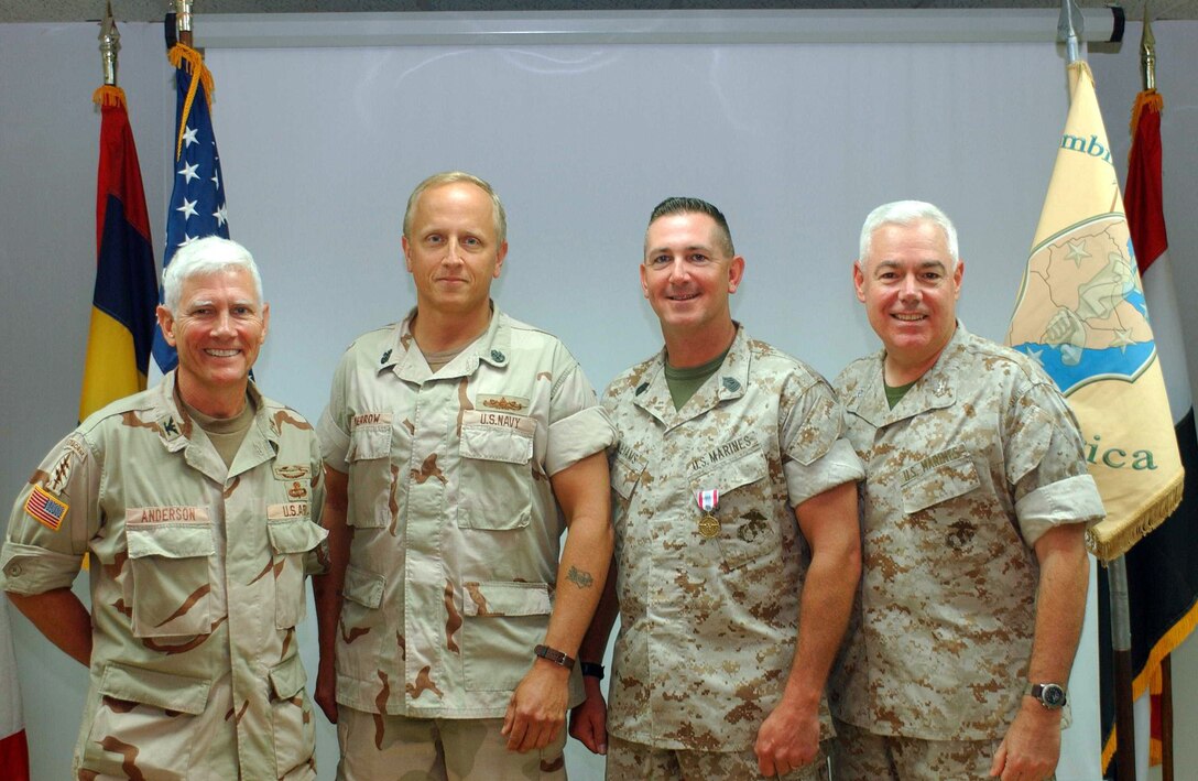 MARINE CORPS BASE CAMP LEJEUNE, N.C. - Members of Combined Joint Task Force - Horn of Africa, Army Col. Edwin W. Anderson, CJ-3 director, Navy Chief Petty Officer Cameron W. Merrow, CJ-3 assistant operations chief, Master Sgt. Orville L. Williams, CJ-3 operations chief and Col. Carl R. Fauser, CJ-3 deputy director have their picture taken after presenting a Defense Meritorious Service Medal to Williams recently.  Williams received the medal for outstanding service during his nine-month deployment to the region.